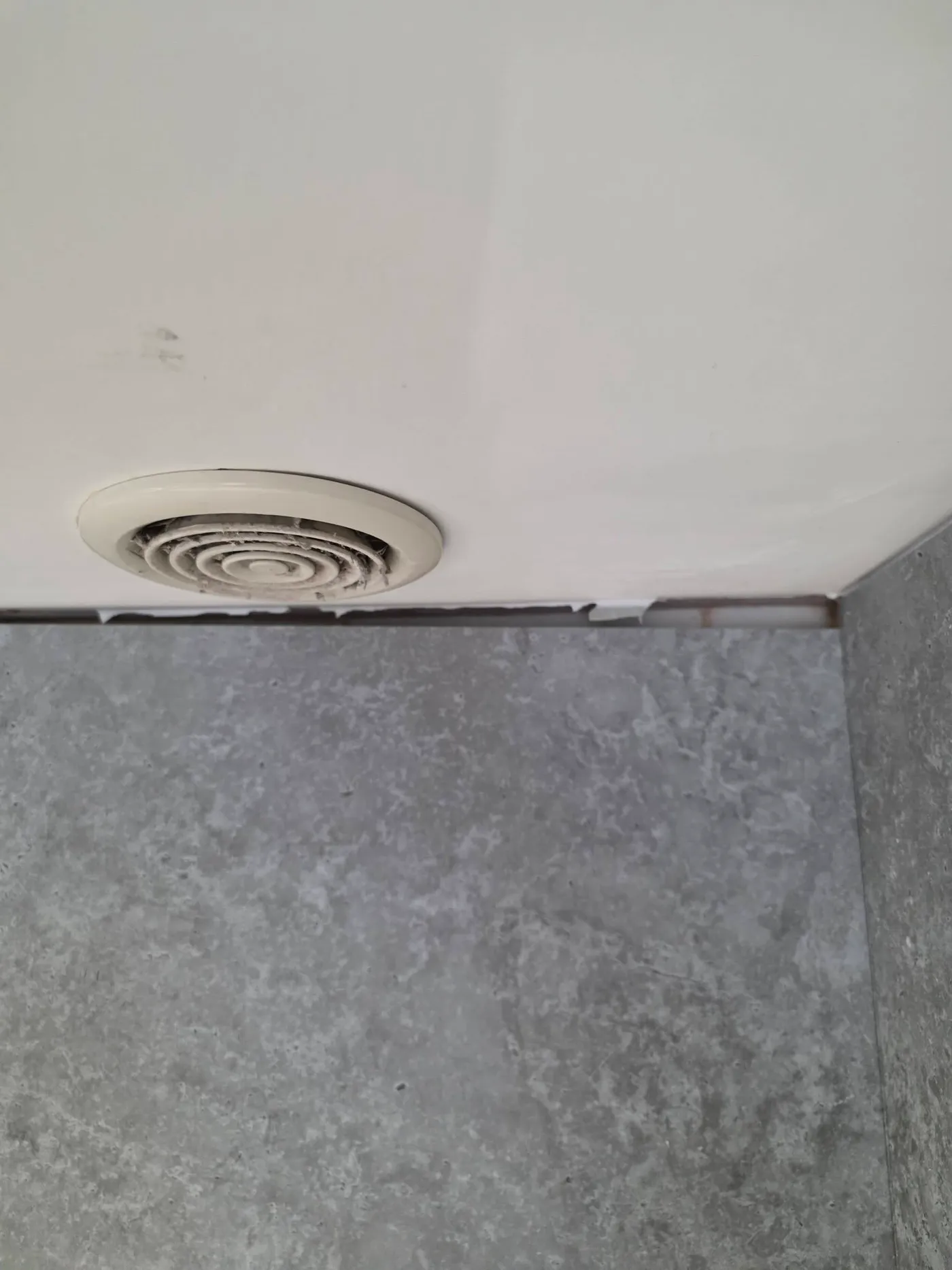 An unfinished junction between the wall panels and ceiling.