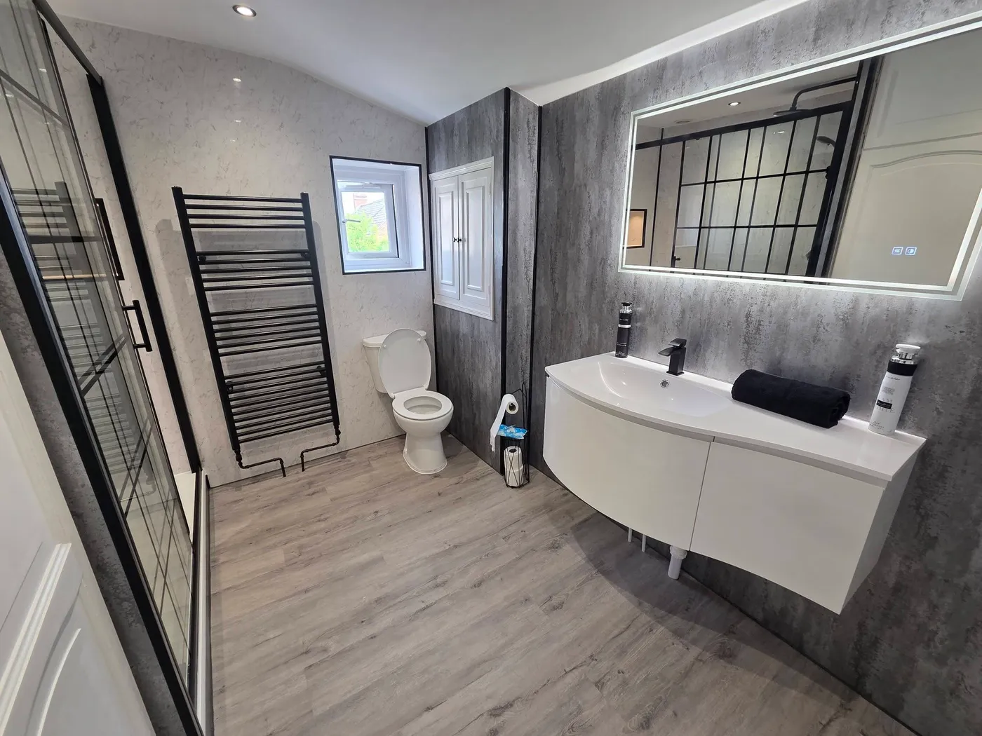 The completed vanity wall, illuminated mirror and relocated towel radiator.