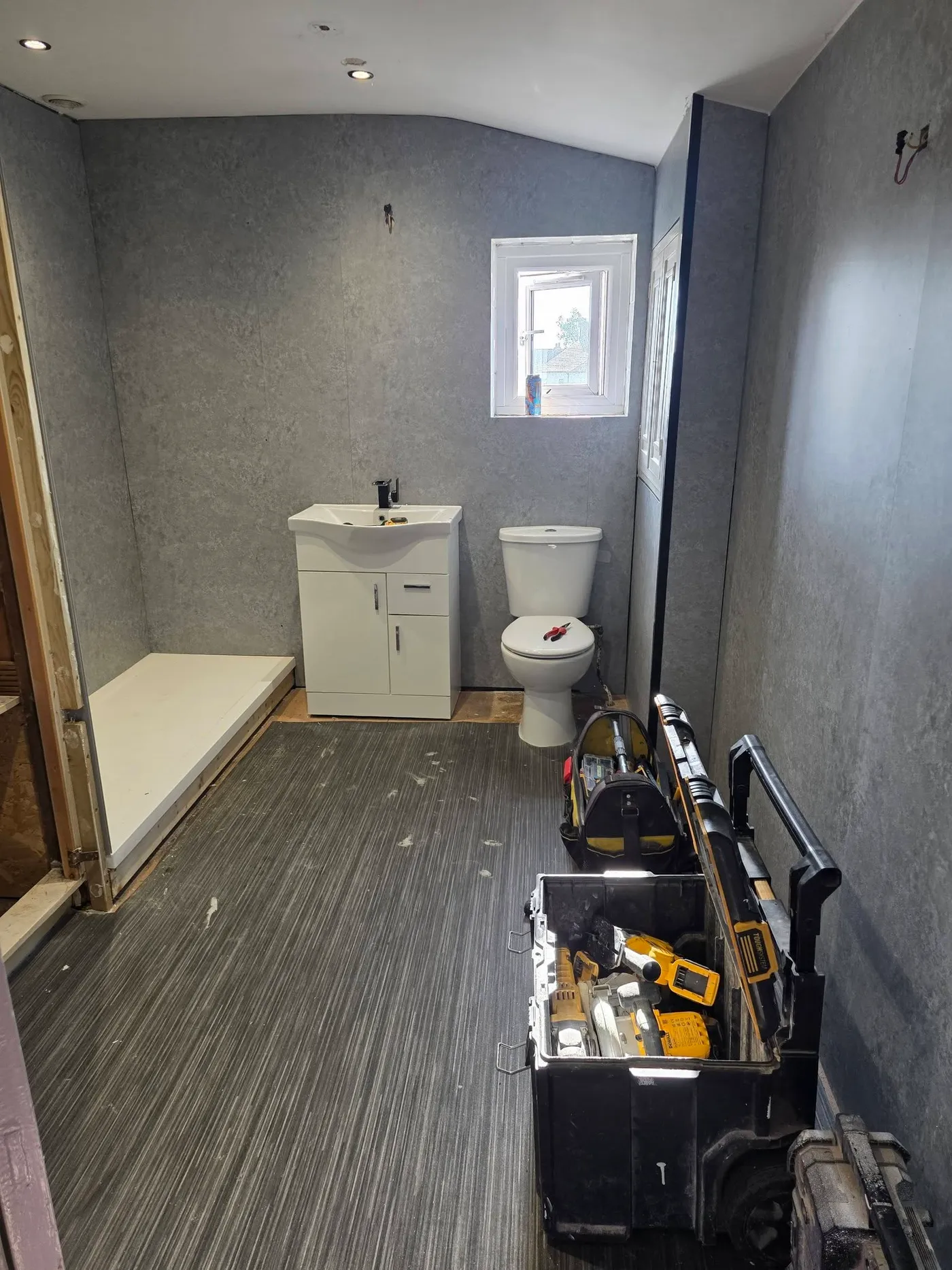 The bathroom before completion, with the previous basin position and tools in the room.