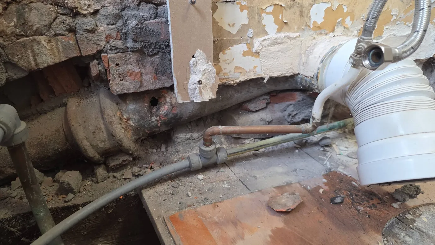 Exposed pipework and masonry during the bathroom works.