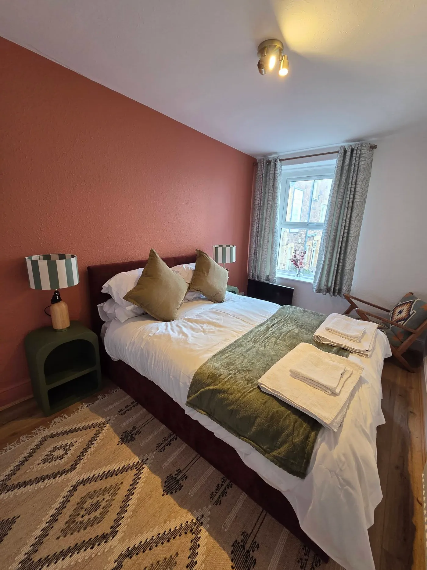 The other bedroom, with a deep-coloured feature wall.